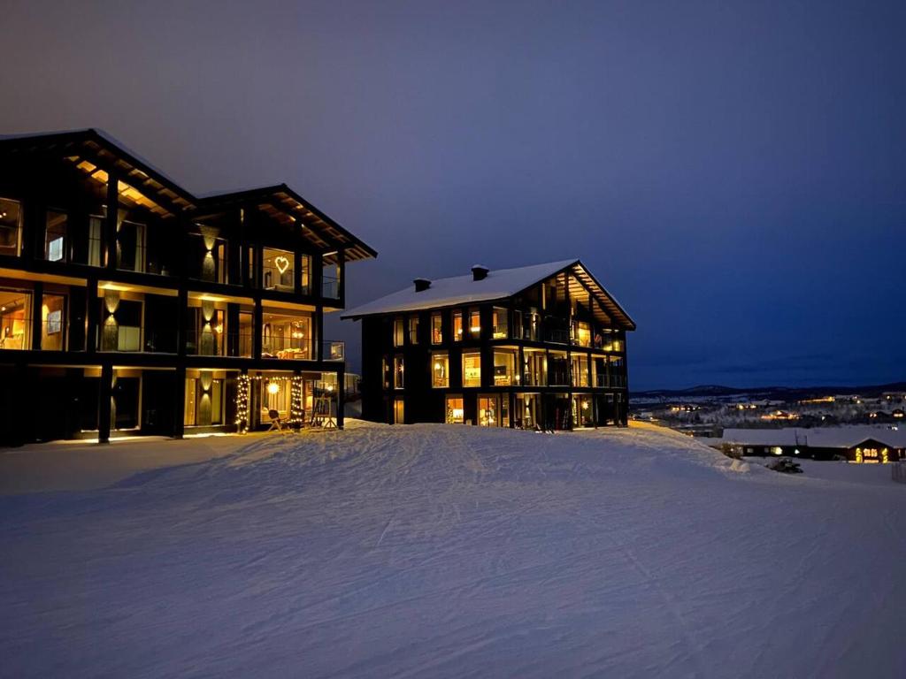 a large building in the snow at night at Kikut Alpin Lodge - Ski In/Ski Out - Ny 2022 in Geilo