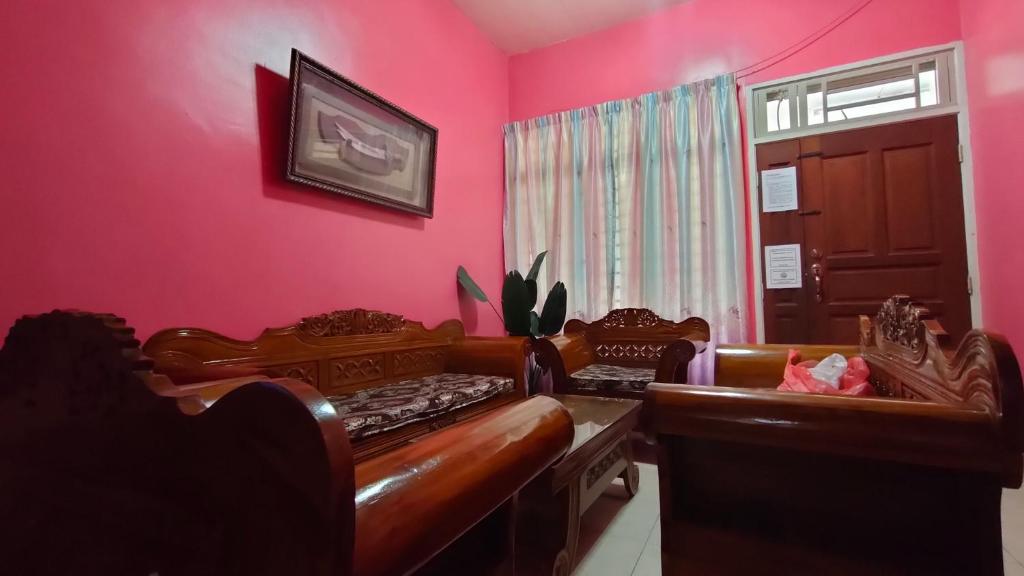 a room with two beds and a pink wall at Zulaikha's Homestay Ulu Tiram Johor Bahru in Ulu Tiram