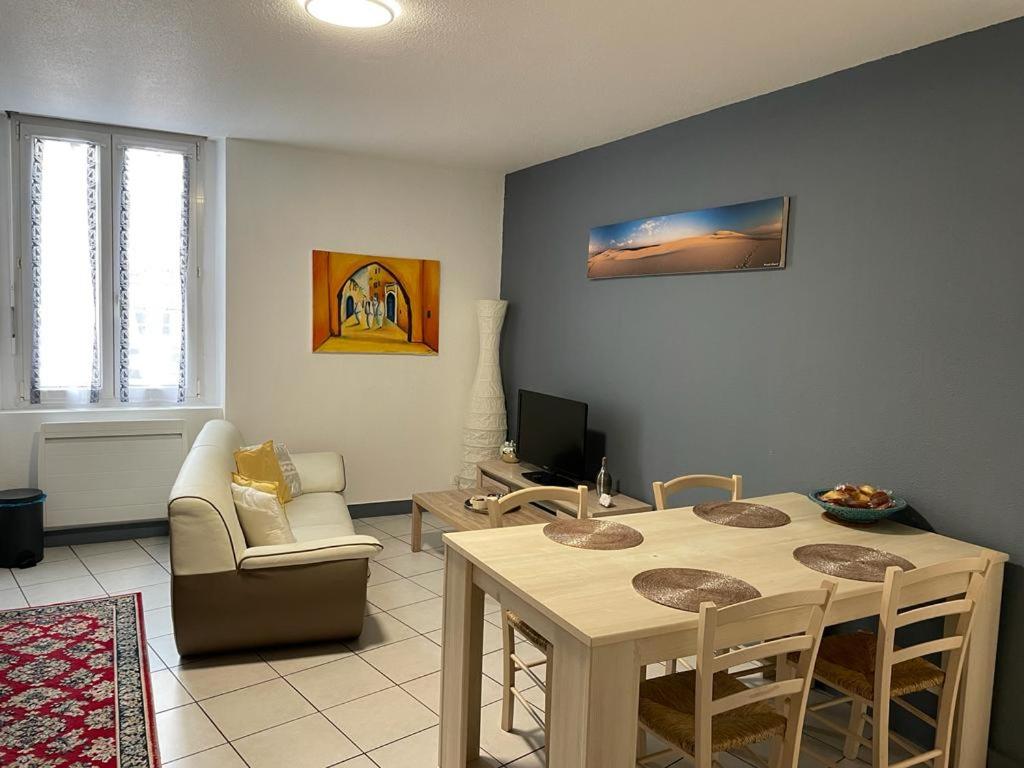 salon ze stołem i kanapą w obiekcie Joli appartement climatisé w mieście Périgueux