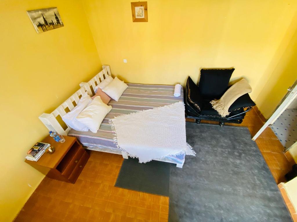 a small room with a bed and a chair at Perfect Travel-Stop Room 3Km From Nanyuki Town - Charell View in Nanyuki