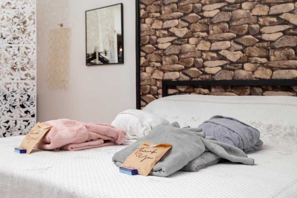 uma cama com toalhas com uma parede de pedra em Hostel Art em Trieste