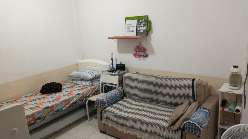 een kleine slaapkamer met een bed en een stoel bij Flat Botafogo in Rio de Janeiro