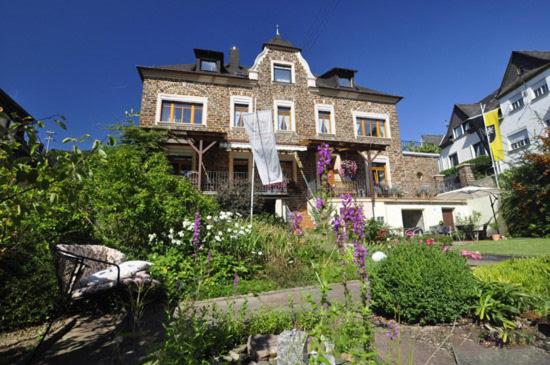 ein großes Steinhaus mit Garten davor in der Unterkunft Altes Weingut an der Vogtei in Senheim