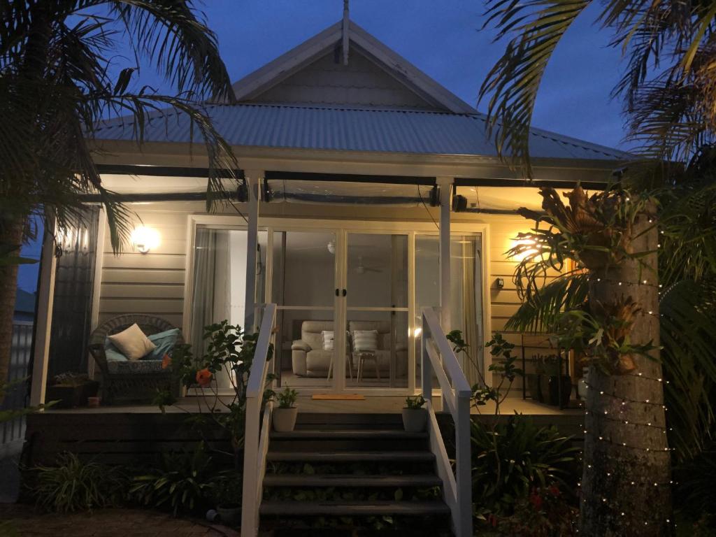 une maison avec une terrasse couverte à l'avant la nuit dans l'établissement Lakeside Bungalow, à Marks Point