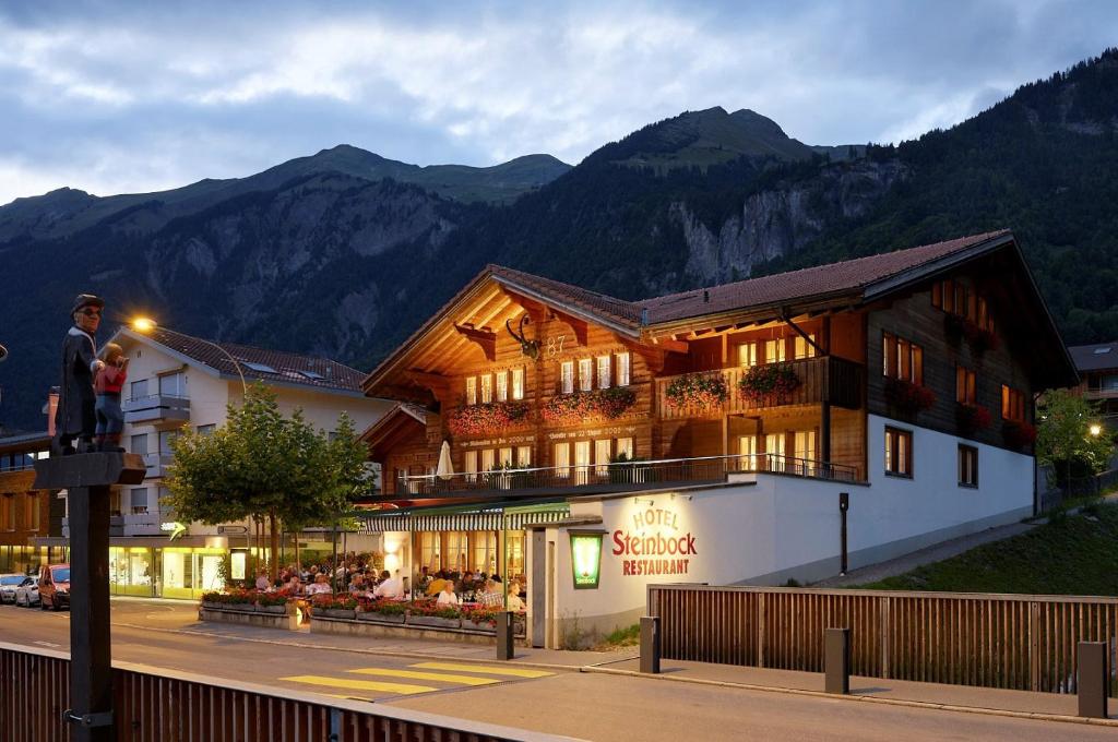 Ein Mann steht auf einer Stange vor einem Gebäude in der Unterkunft Hotel Steinbock in Brienz