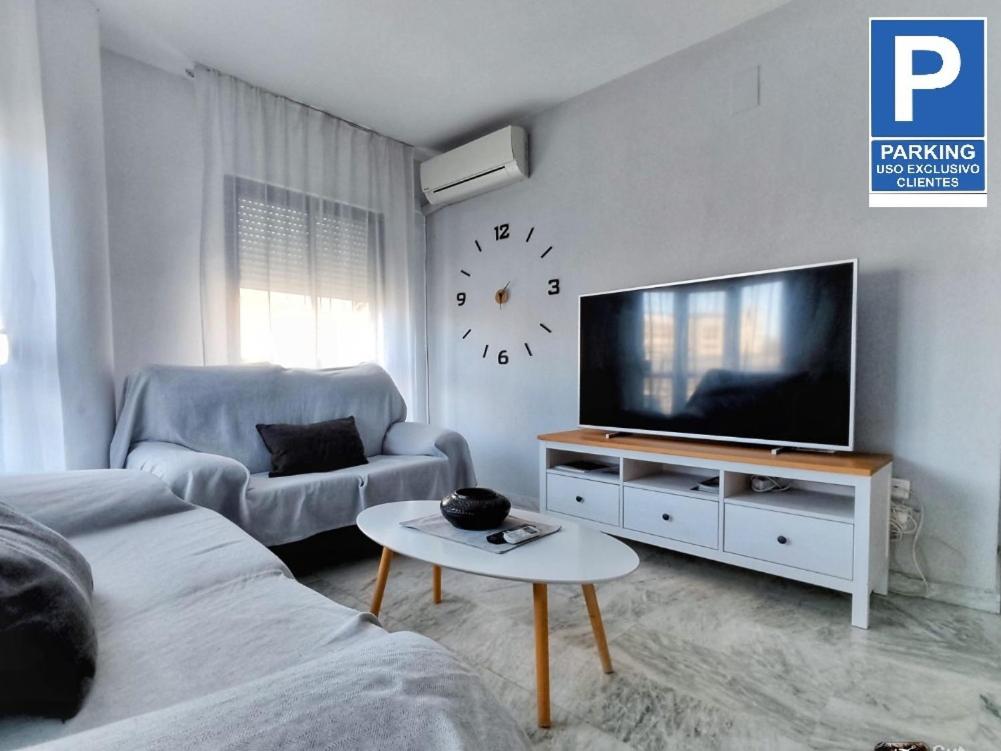 ein Wohnzimmer mit einem TV und einem Sofa in der Unterkunft Apartamento y Parking en pleno CENTRO, DAMAS in Huelva