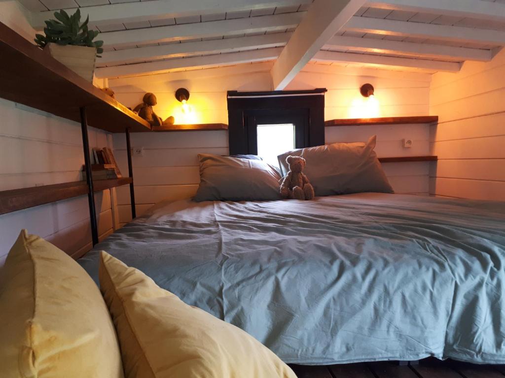 een slaapkamer met een bed met een teddybeer erop bij Tiny house, sauna hot tub Gesves Namur Ardennes in Gesves