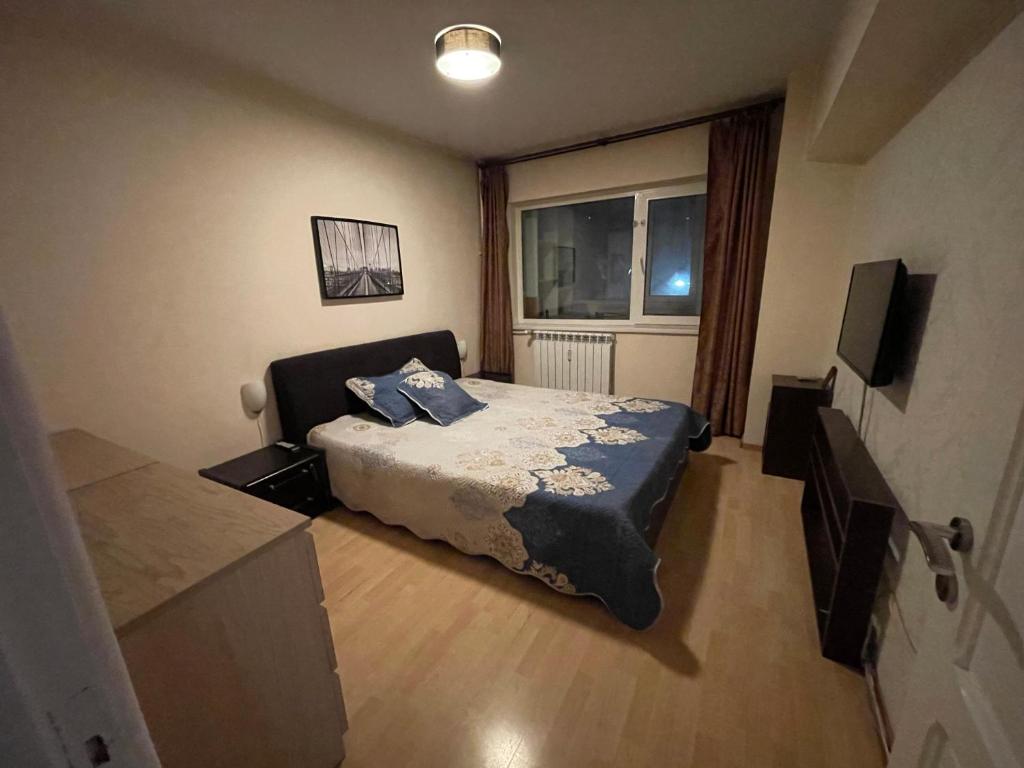 a small bedroom with a bed and a window at Majestic Luxury Apartment Close to Presidential Palace in Bucharest
