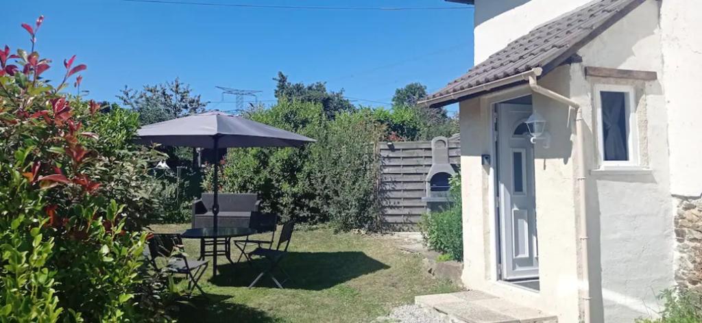 a garden with a table and an umbrella at Le Fry Holiday Gite in Lithaire