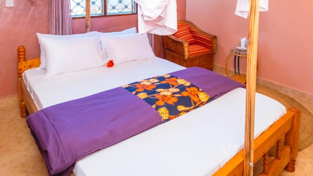 sypialnia z 2 łóżkami z białą pościelą w obiekcie Rudi House w mieście Msaranga