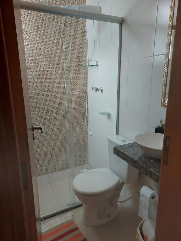 een badkamer met een douche, een toilet en een wastafel bij Casa em São Lourenço-MG in São Lourenço