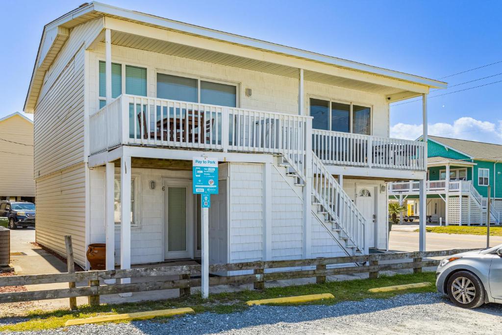 a house with a balcony and a car parked in front at Seaview Duplex 6 & 7 in Kure Beach