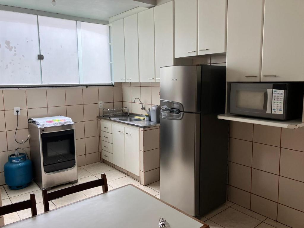 a kitchen with a stainless steel refrigerator and a microwave at Apartamento 2 quartos Setor Sul in Goiânia
