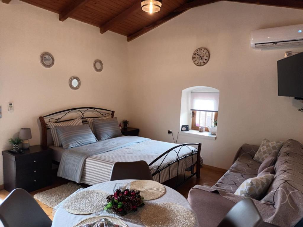 um quarto com uma cama e um sofá em Panagiotas House em Monemvasia
