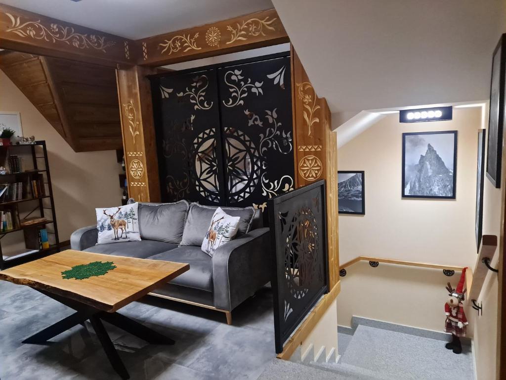 uma sala de estar com um sofá e uma mesa em Willa Wschód Słońca em Bukowina Tatrzańska