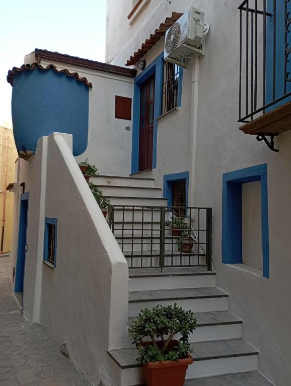 a white building with blue doors and stairs at A casa dell’amica mia in San Nicola Arcella