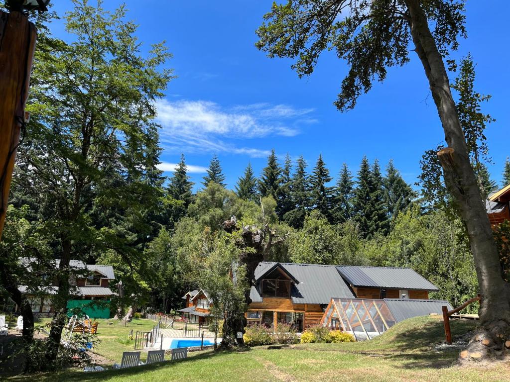 ein Haus mit Pool und Bäumen im Hintergrund in der Unterkunft Portal del Manzano in Villa La Angostura