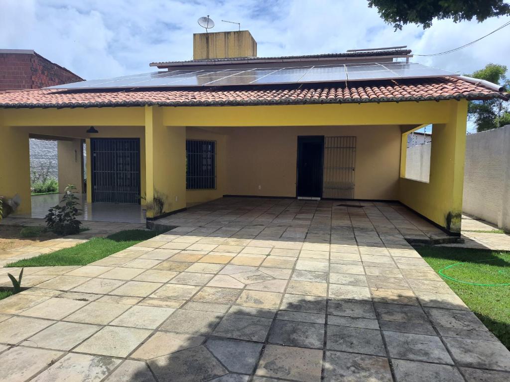 ein kleines gelbes Haus mit einer Terrasse in der Unterkunft Hostel Atairú in Natal