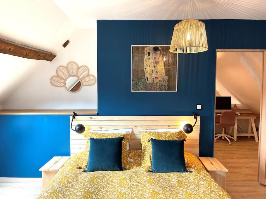 - une chambre avec des murs bleus et un lit avec des oreillers bleus dans l'établissement Maison de vacances dans un village de charme, 