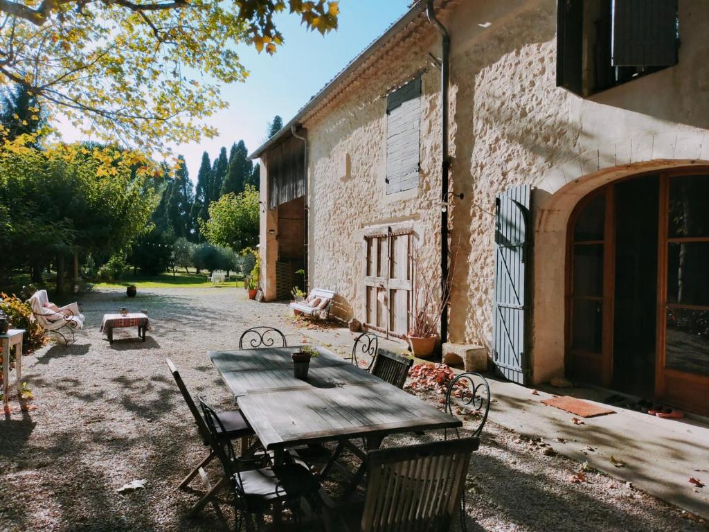 a wooden table and chairs outside of a building at Rêve d’Emma in Plan-dʼOrgon