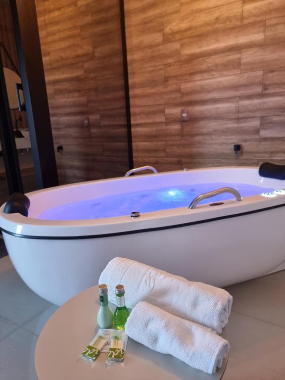 een badkamer met een bad en een tafel met handdoeken bij Hotel Itatiaia in Tangara da Serra