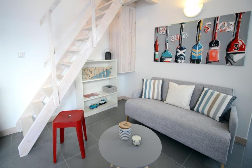 a living room with a couch and a staircase at Le Clos des Flots - La Dune in La Flotte