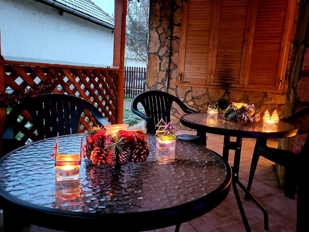 WatAir House Apartman Sarud في Sarud: طاولتين مع الشموع فوقهما على الفناء