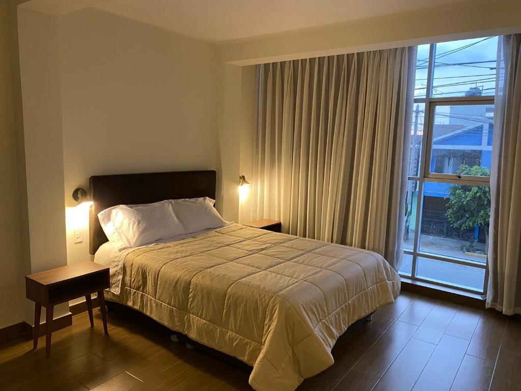 um quarto com uma cama e uma grande janela em Hotel Alba em Ica