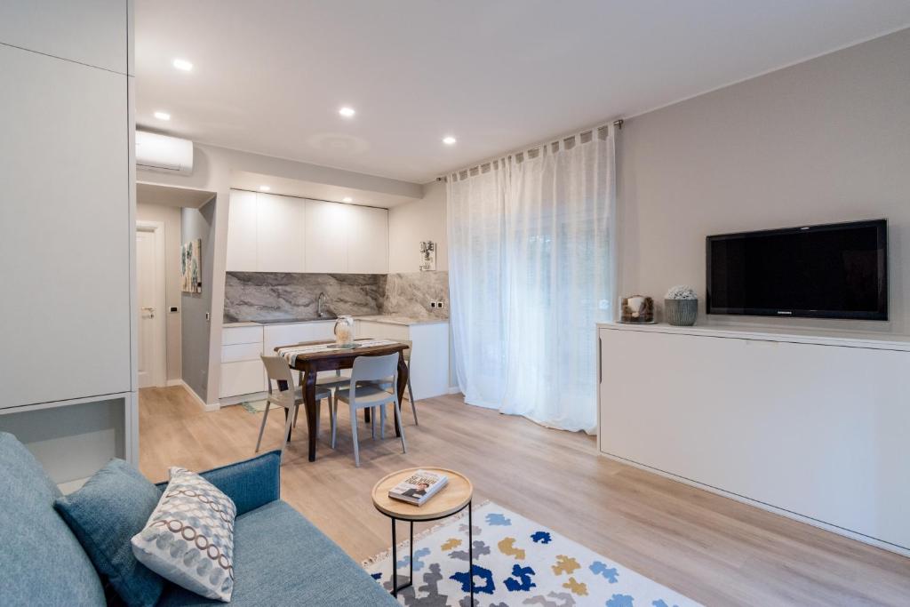 uma sala de estar com um sofá azul e uma mesa em Ariston & Casinò - Appartamento con Giardino e Garage em Sanremo