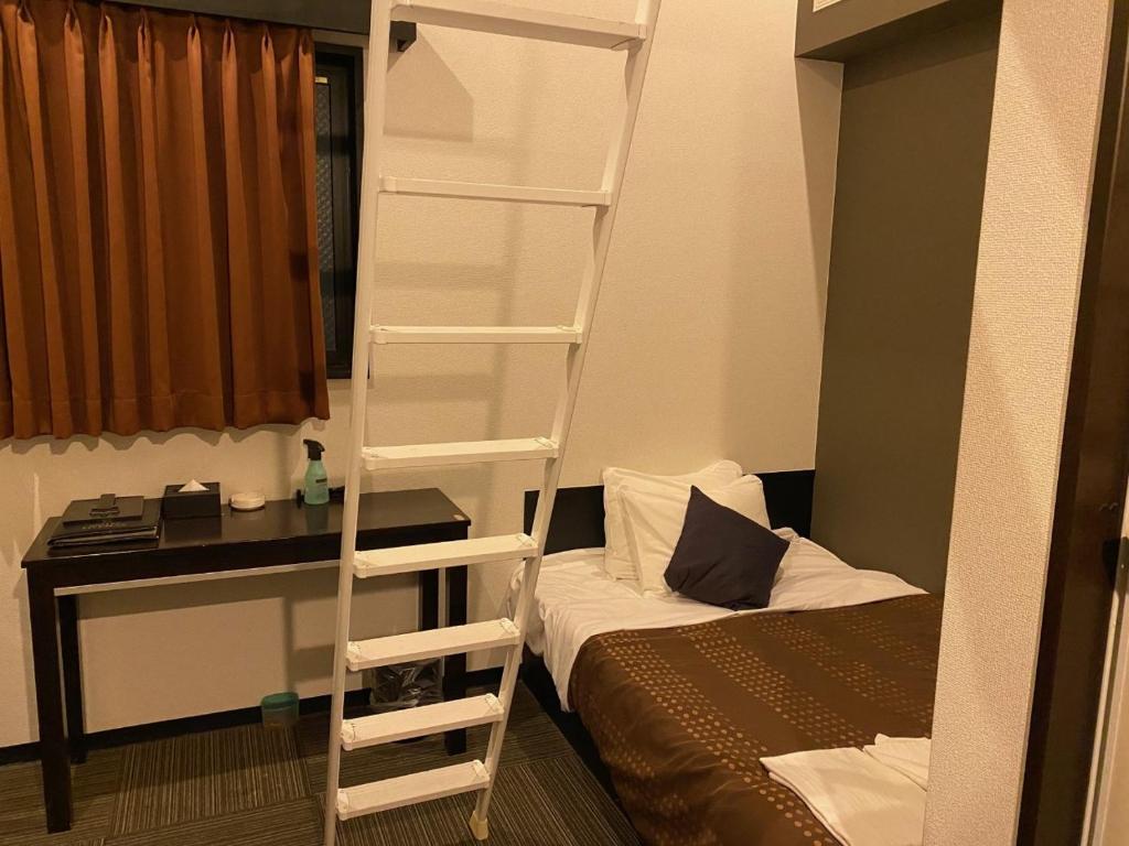 Postel nebo postele na pokoji v ubytování HOTEL LiVEMAX BUDGET Esaka