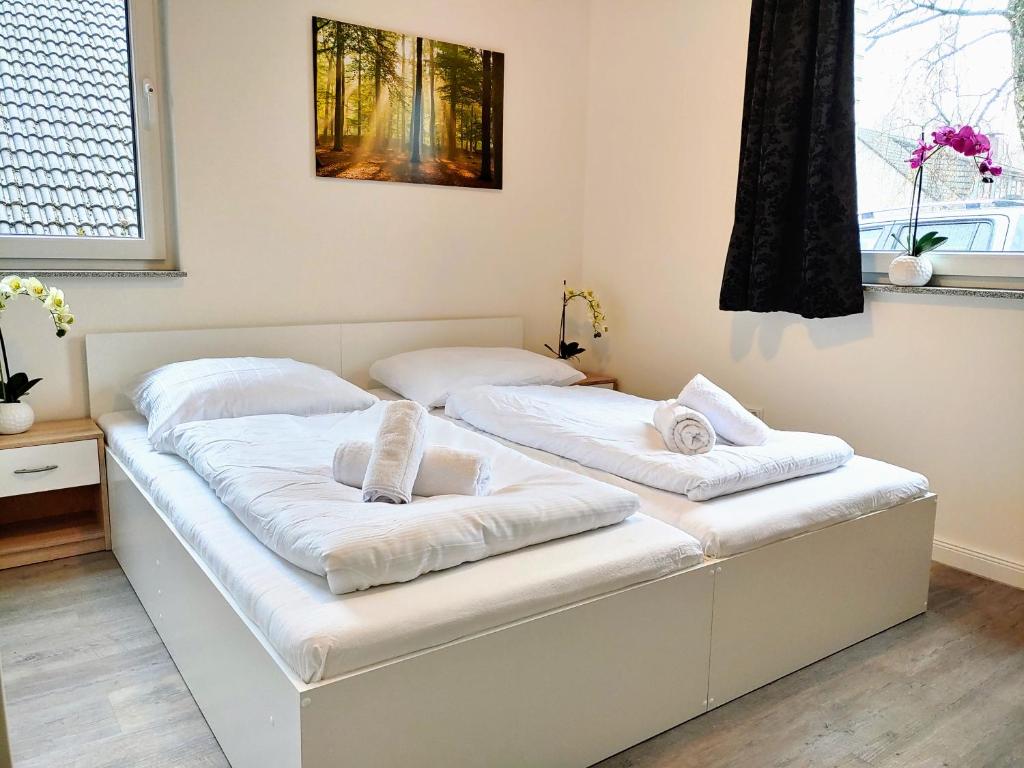 two beds in a room with white sheets at Aparthotel "Dat Witte Hus" Komfortables Apartment für 6 Personen in Geesthacht
