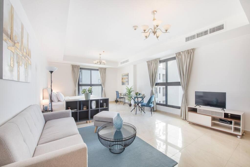 a living room with a couch and a tv at Elegant Studio with Canal View and Close to Metro in Dubai