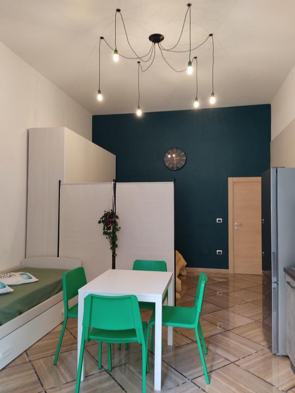 une salle à manger avec une table blanche et des chaises vertes dans l'établissement Domus vacanze Alfieri, à Manfredonia