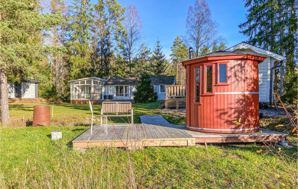a red tiny house on a deck in a yard at Beautiful Home In Morgongva With Sauna, 3 Bedrooms And Wifi 