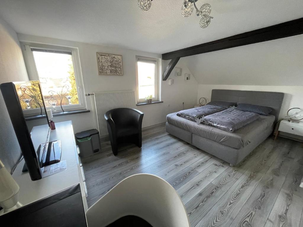 1 Schlafzimmer mit einem Bett, einem Schreibtisch und 2 Fenstern in der Unterkunft "An der Lindenberganlage" in Melsungen