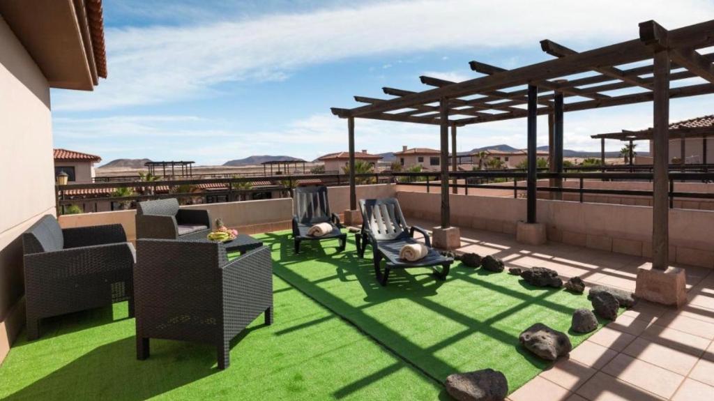 a patio with grass and chairs on a roof at Paradise Island in Lajares