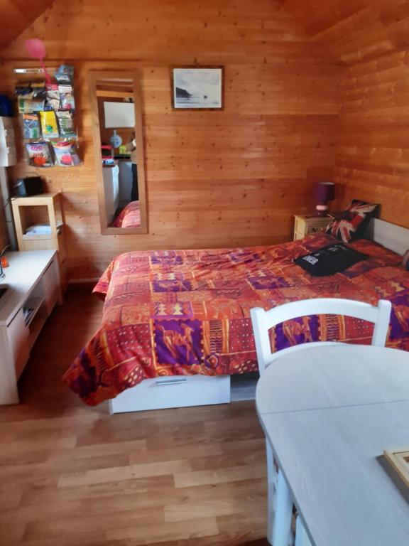 sypialnia z łóżkiem w drewnianym pokoju w obiekcie Chalet insolite w mieście Saint-Georges-de-Livoye