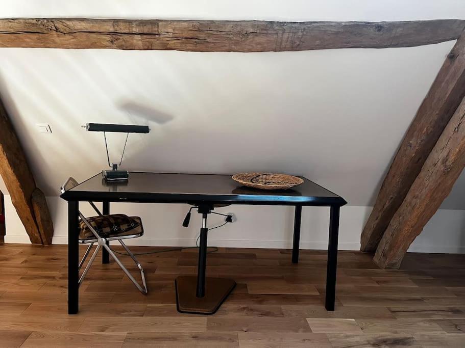 a black table in a room with a lamp on it at Gîte des 3 Marchands in Buzançais