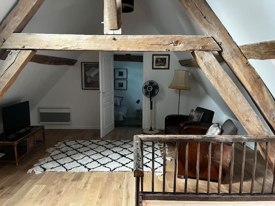 a living room with a vaulted ceiling and a room with a couch at Gîte des 3 Marchands in Buzançais