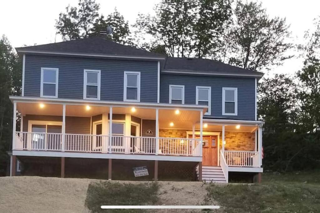 a large blue house with a porch and balcony at Ride from this Mini Mansion to all the ATV Trails in Berlin