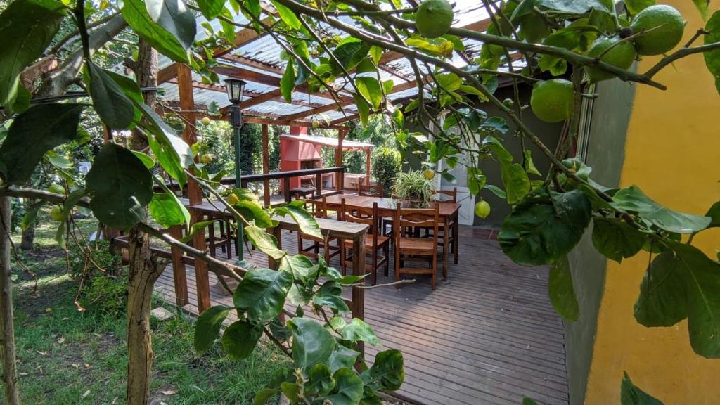 une terrasse en bois avec une table et des chaises. dans l'établissement Casa del Bosque, à Mar del Plata
