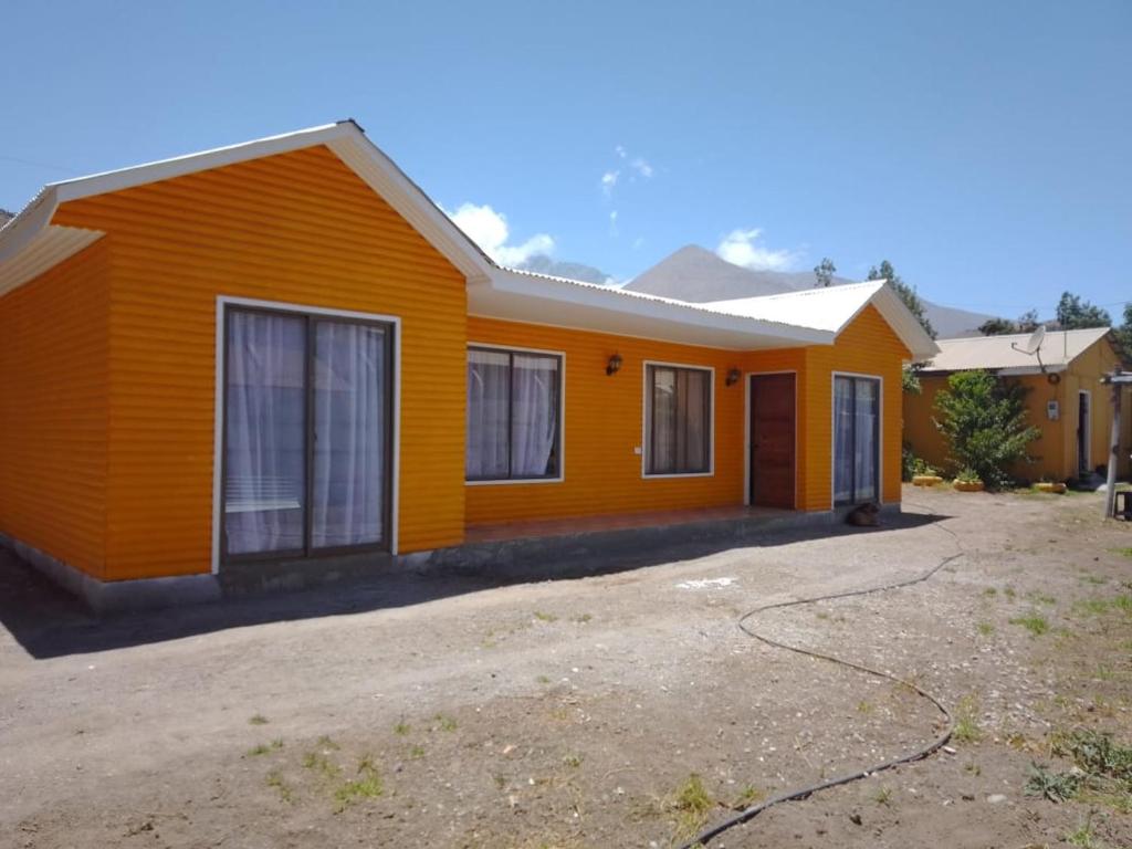 an orange house with a driveway in front of it at Granja Vip Valle de Elqui in Vicuña