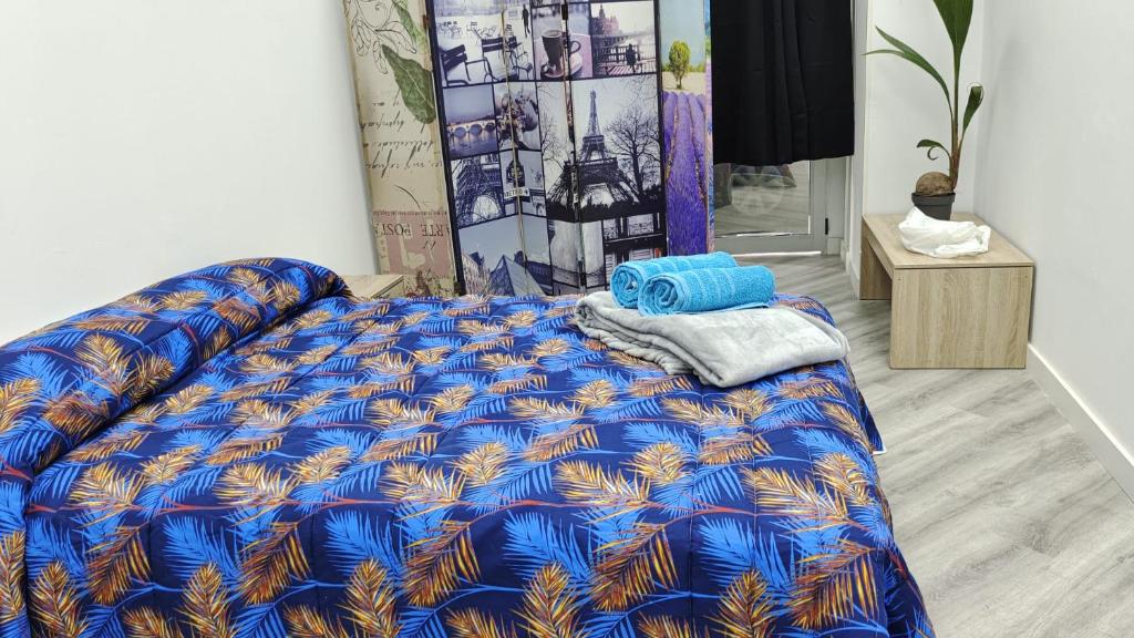 1 cama con edredón azul en una habitación en Lodge El Muelle De Arinaga, en Arinaga