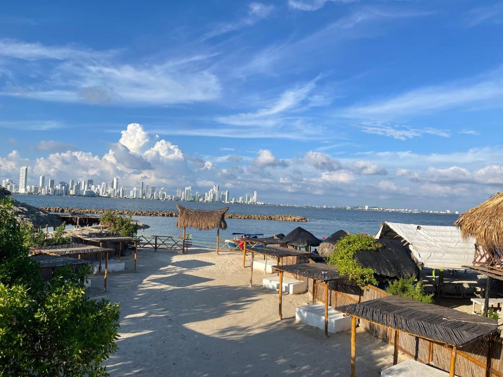 ein Strand mit Bänken und eine Stadt im Hintergrund in der Unterkunft CABAÑA EN ISLA FRENTE A CARTAGENA in Cartagena de Indias