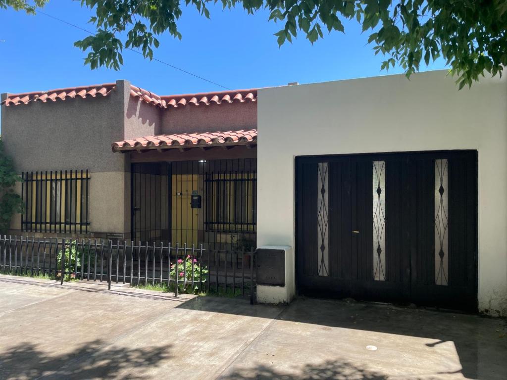 una casa con una puerta negra y una valla en CASA LAS PARRAS en San Rafael