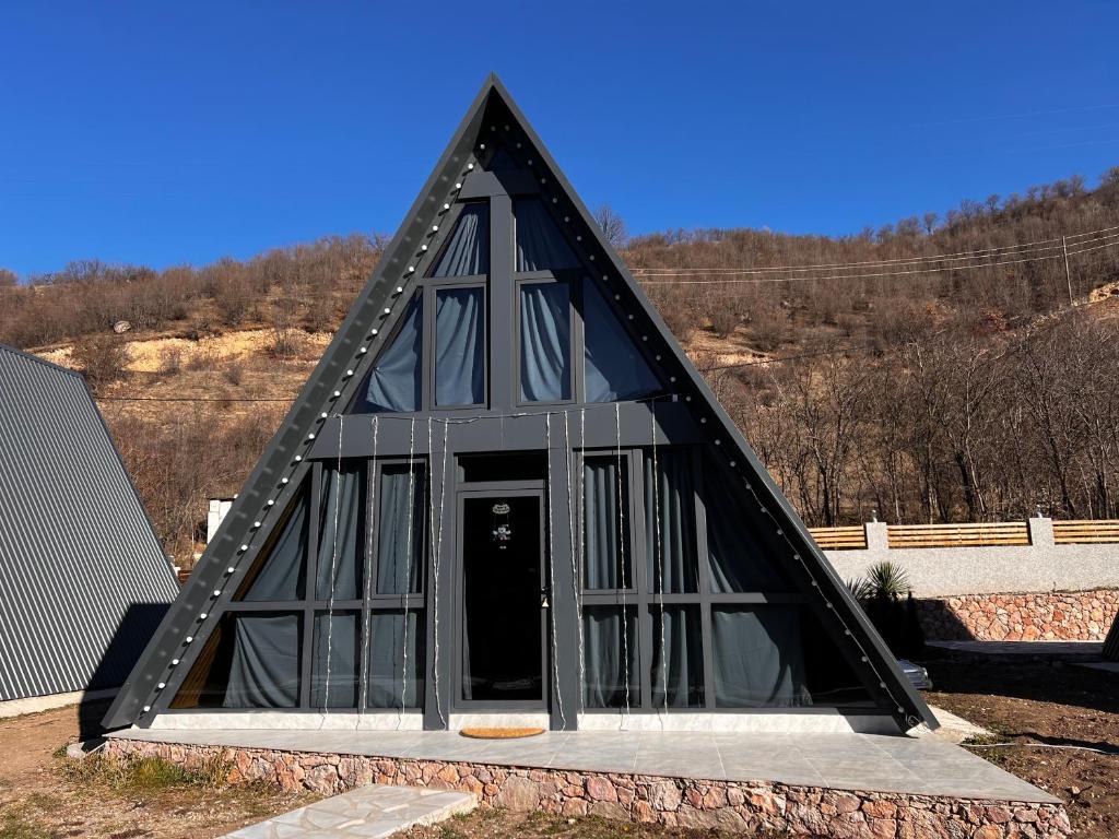 a black triangular building with a door in the middle at Green Villa Resort Grey in Dilijan