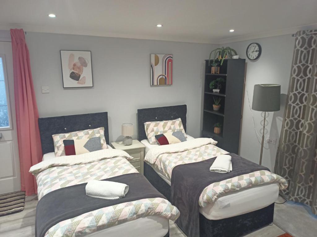um quarto com 2 camas individuais e um candeeiro em Brand New Cosy Apartment 3 Sleep, Garden access Free Wi-Fi & Parking em Newport