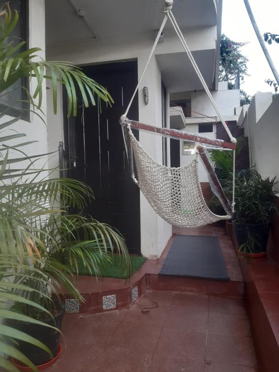 a porch with a hammock in front of a house at Cornwall for Couple in Madikeri