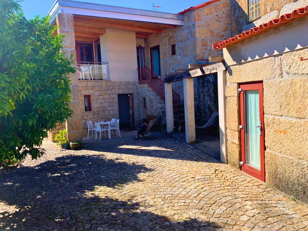 マングァルデにあるCasas d Aldeia Turismo Ruralのパティオ(テーブル、椅子付)が備わる家です。