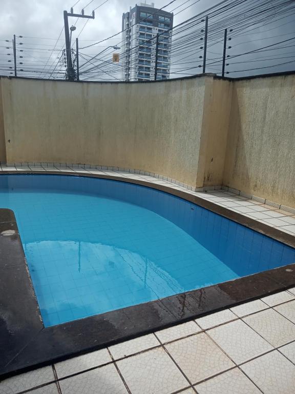 uma piscina com água azul num edifício em Aconchego em São Luís